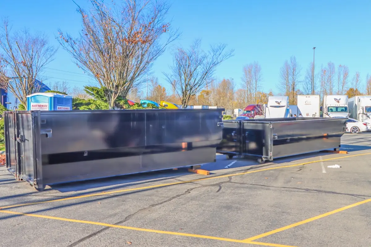 Professional dumpster rental service with roll-off container on residential driveway in Bon Air